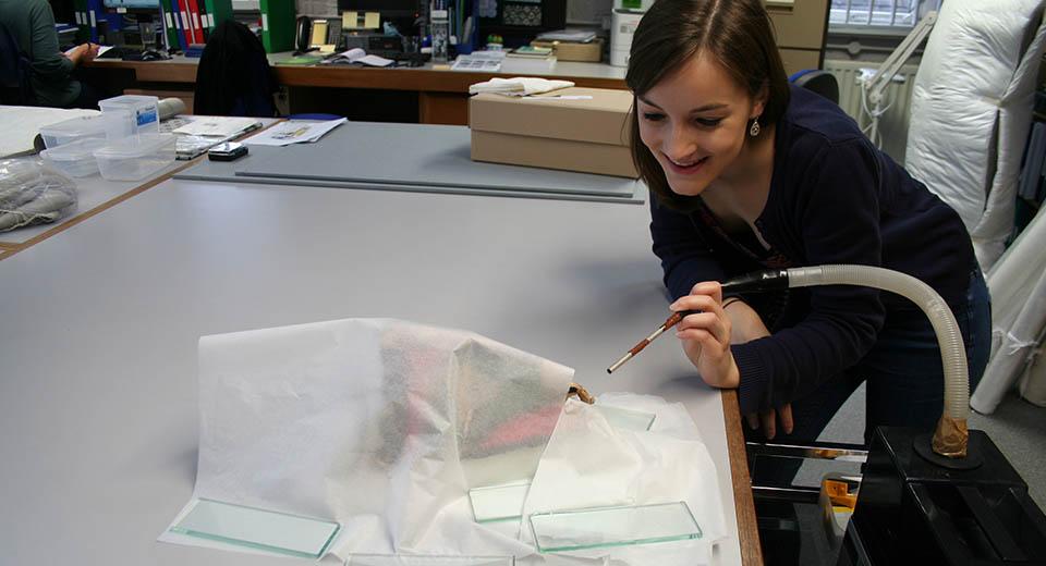 Conservator working on the ethnographic mask