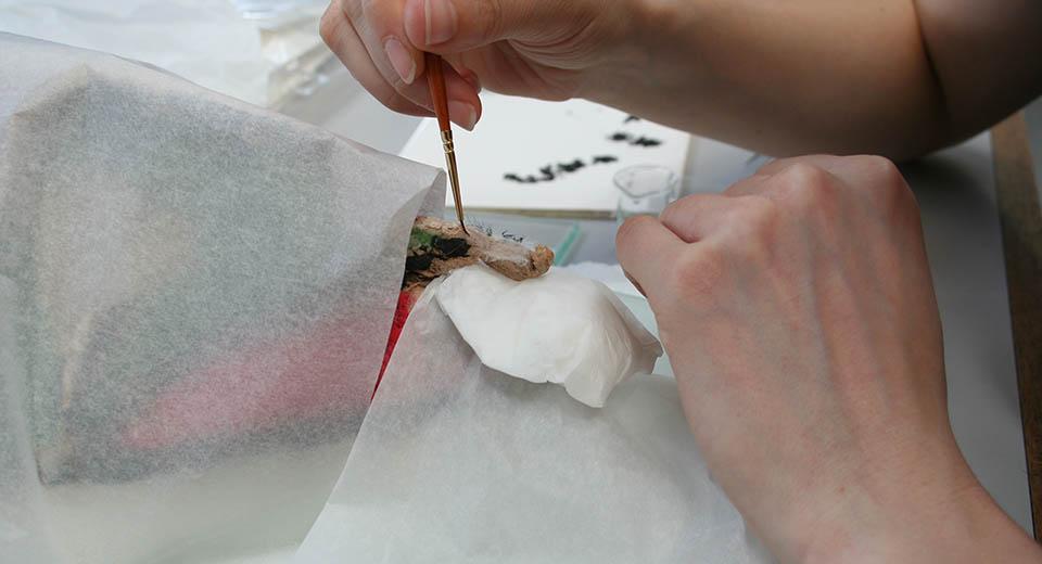 Conservator working on the ethnographic mask