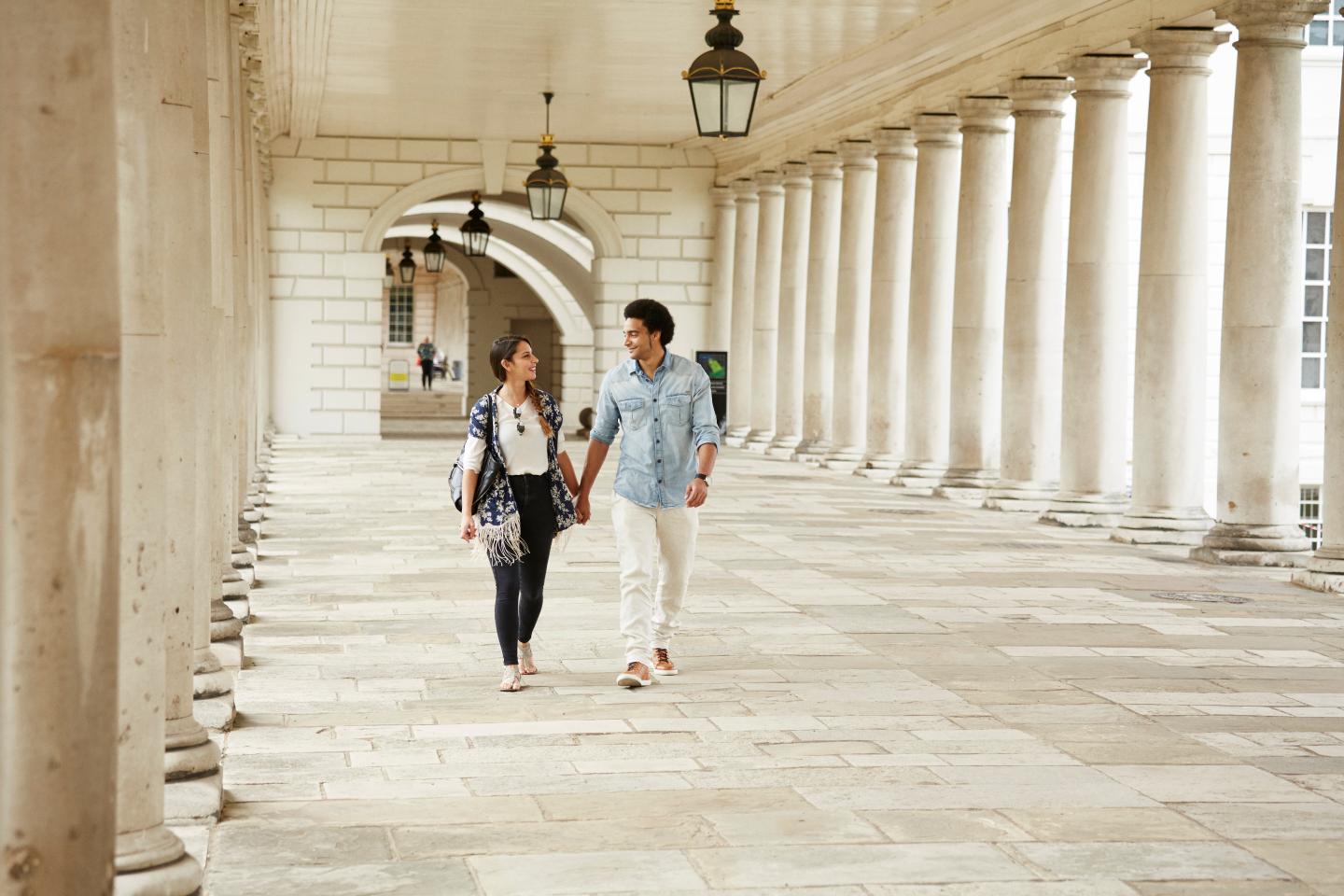 Couple walking through the Queen's House colonnades