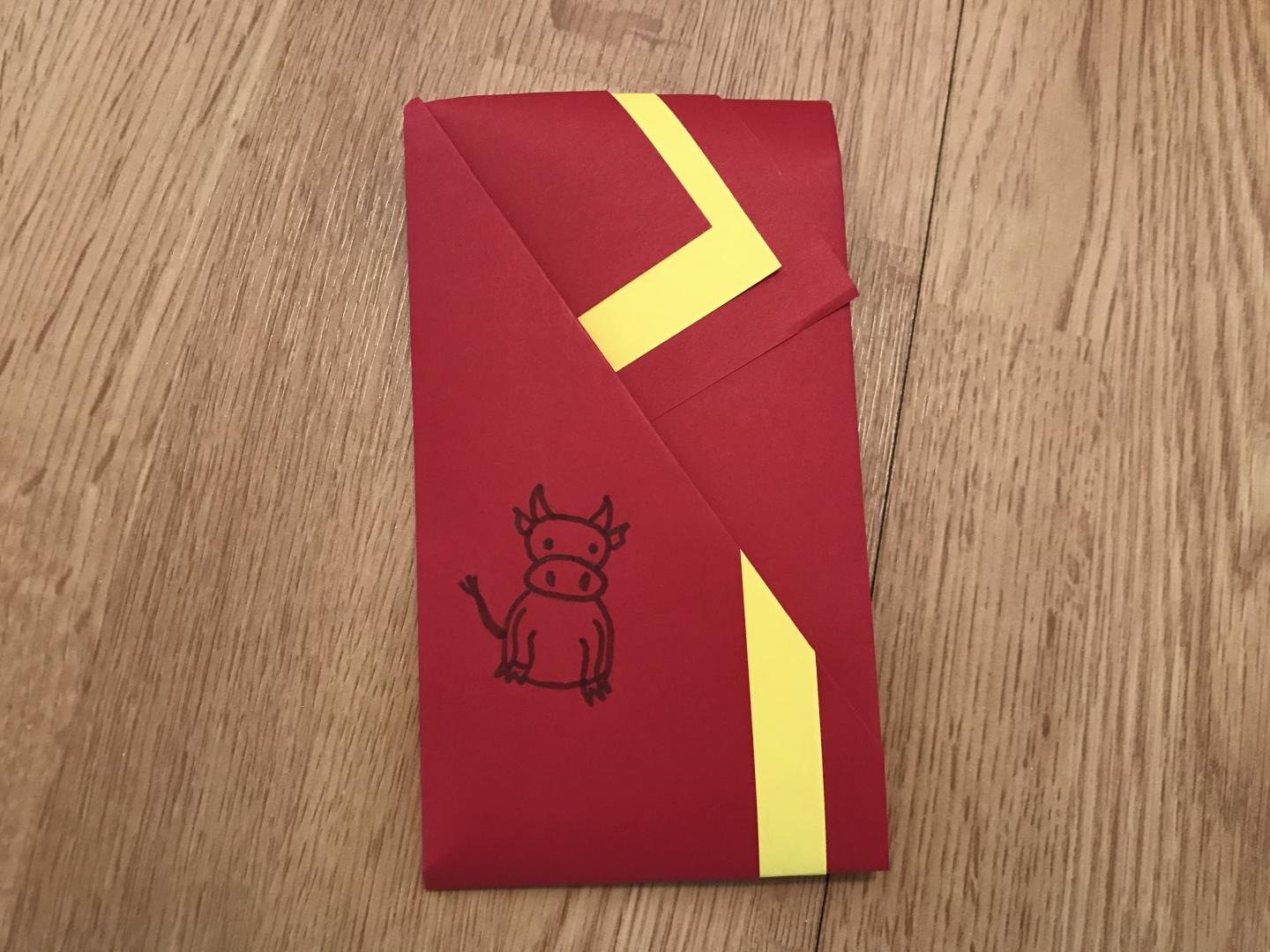 A red and yellow envelope made by folding. A small ox is drawn on the front.