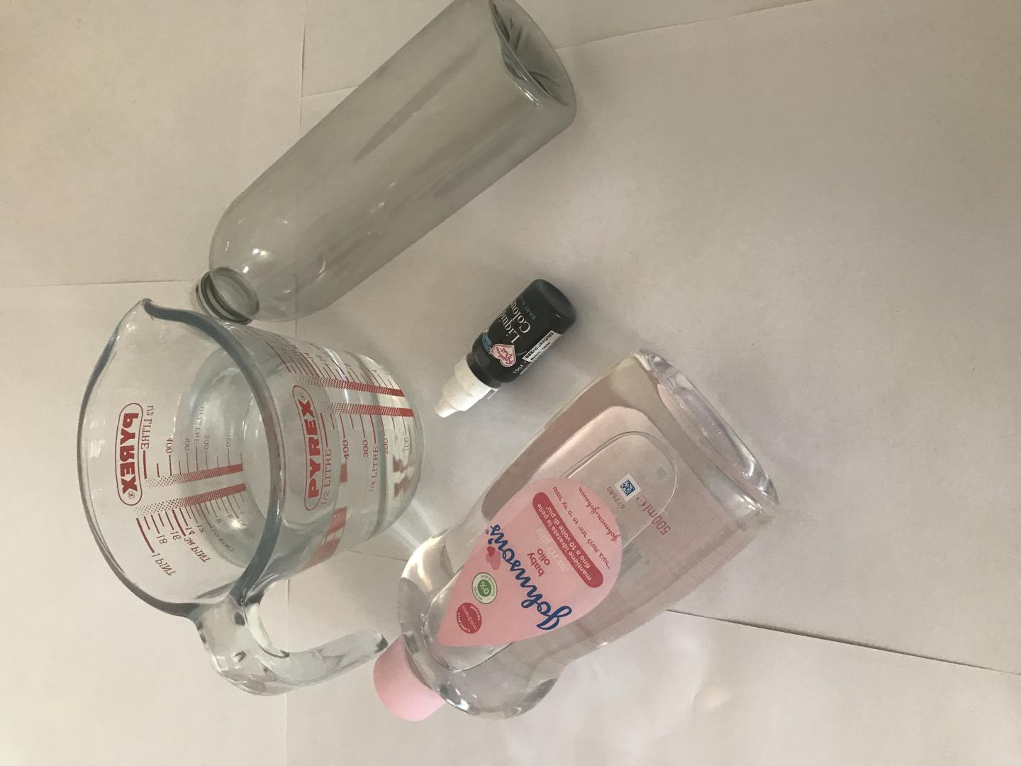 measuring jog of water, blue food dye, plastic bottle, bottle of baby oil