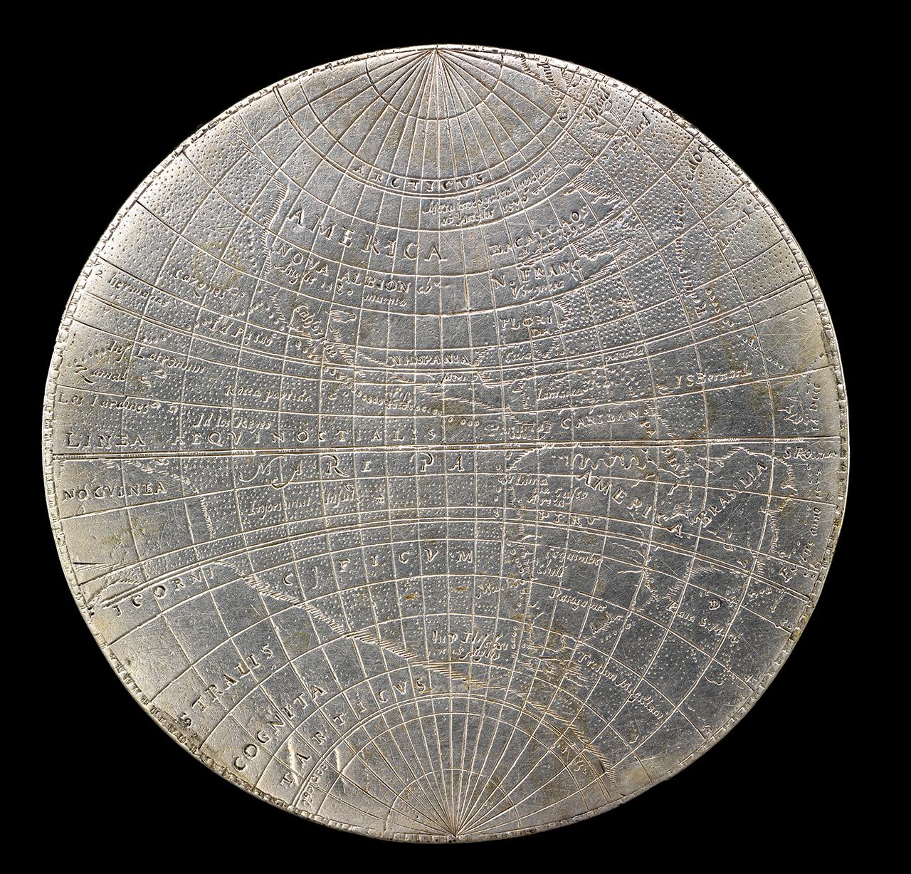 Collection image of medal with engraved world map including latitude and longitudinal lines