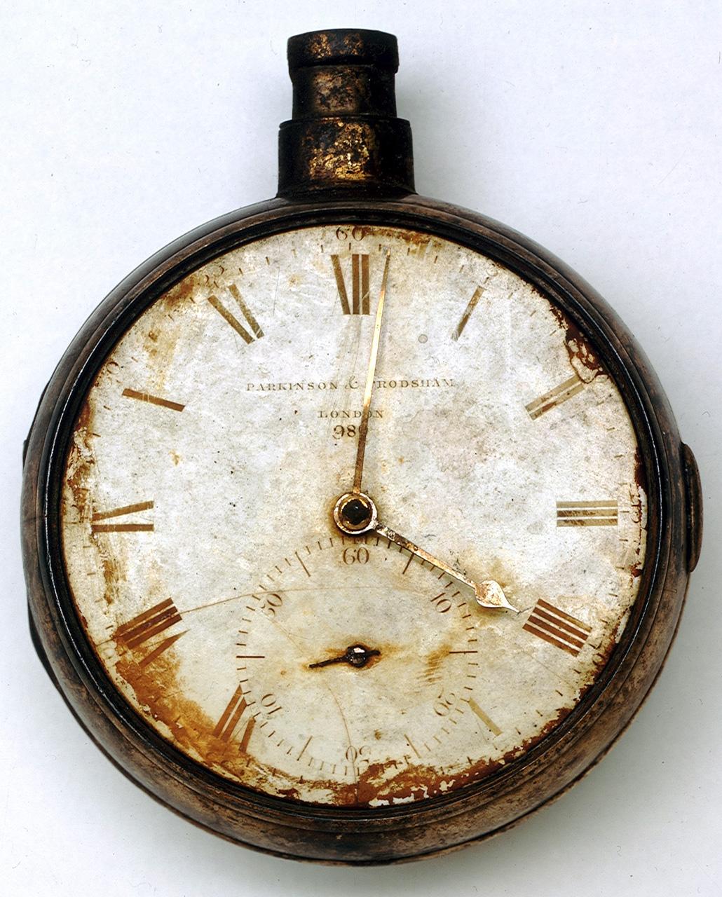 A rusted pocket watch or 'chronometer', with discoloured glass case and dials