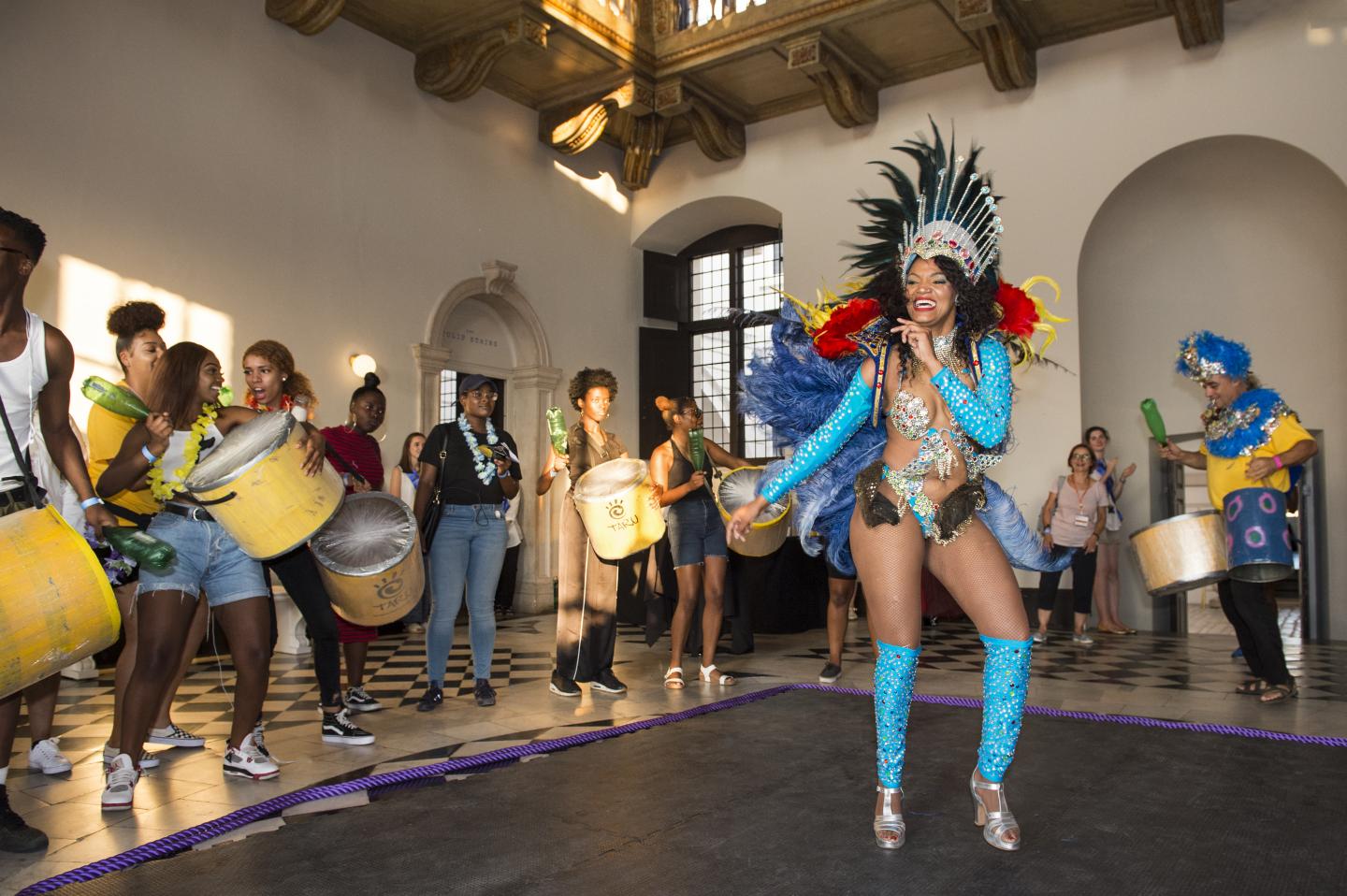 A youth carnival in the queens house with young people drumming and dancing