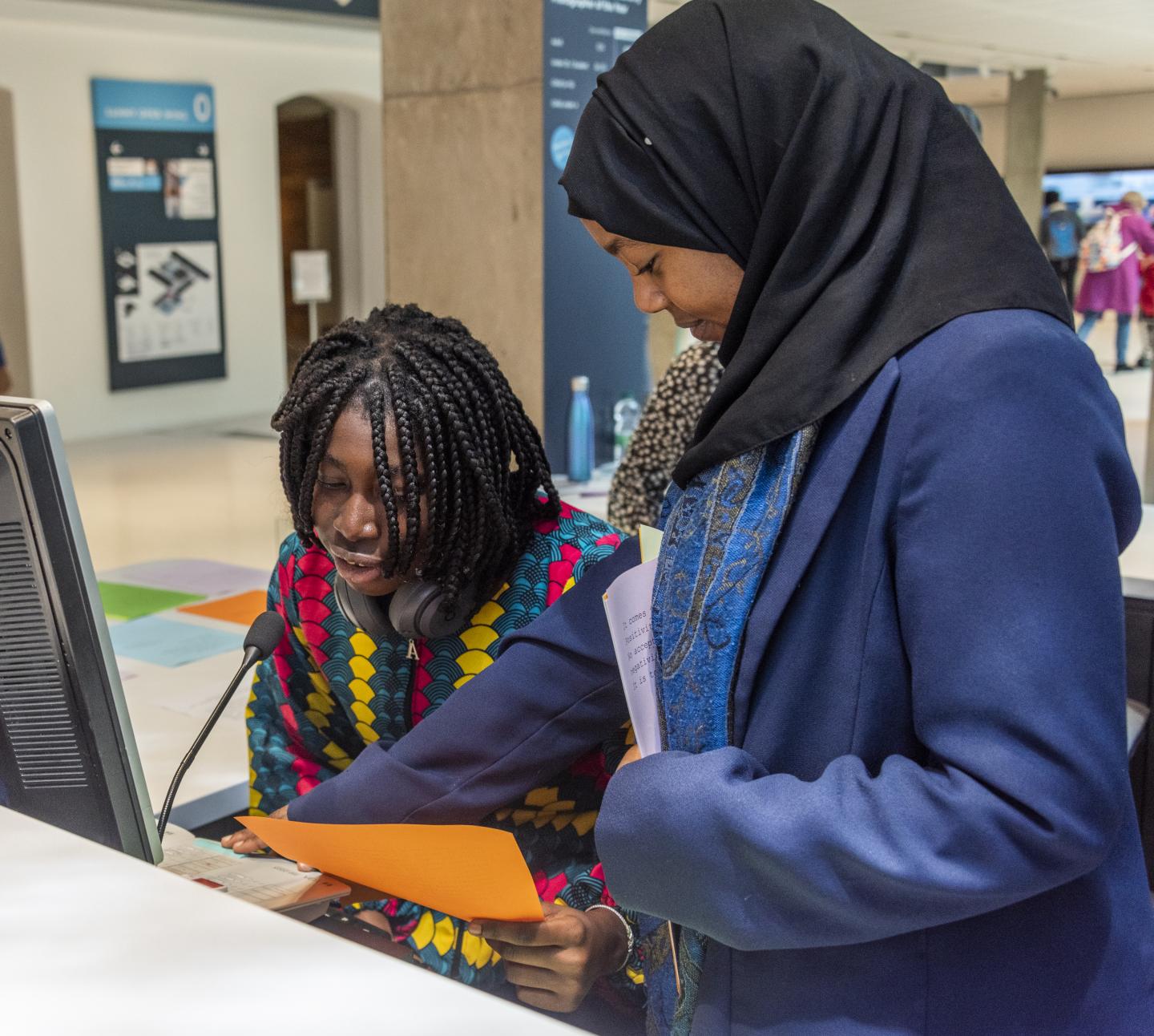 Two young people are reading out loud over the Tannoy System in the museum as part of the Tannoy Takeover