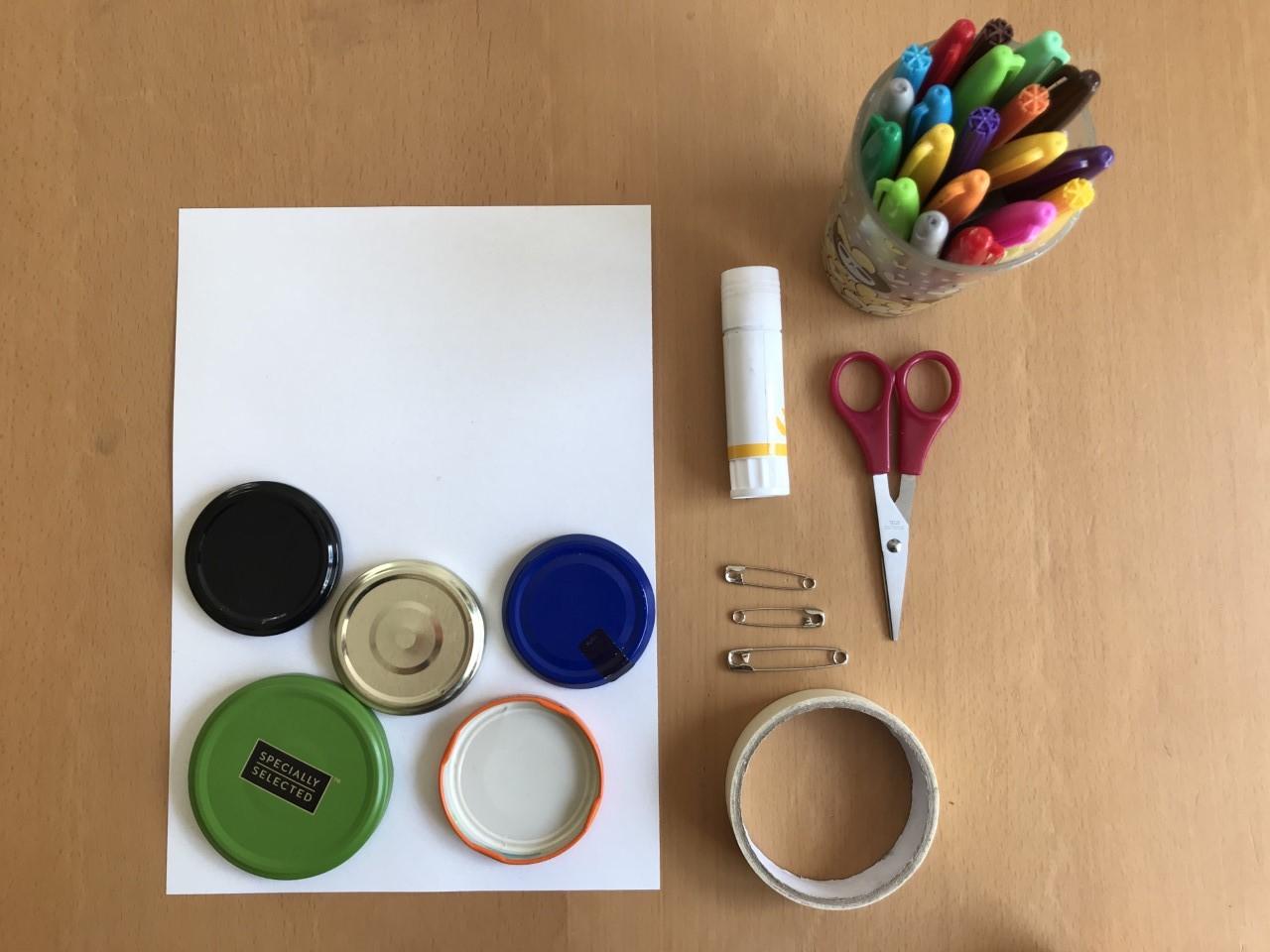 sheet of white paper, jam jar lids, glue, tape, scissors and coloured pens