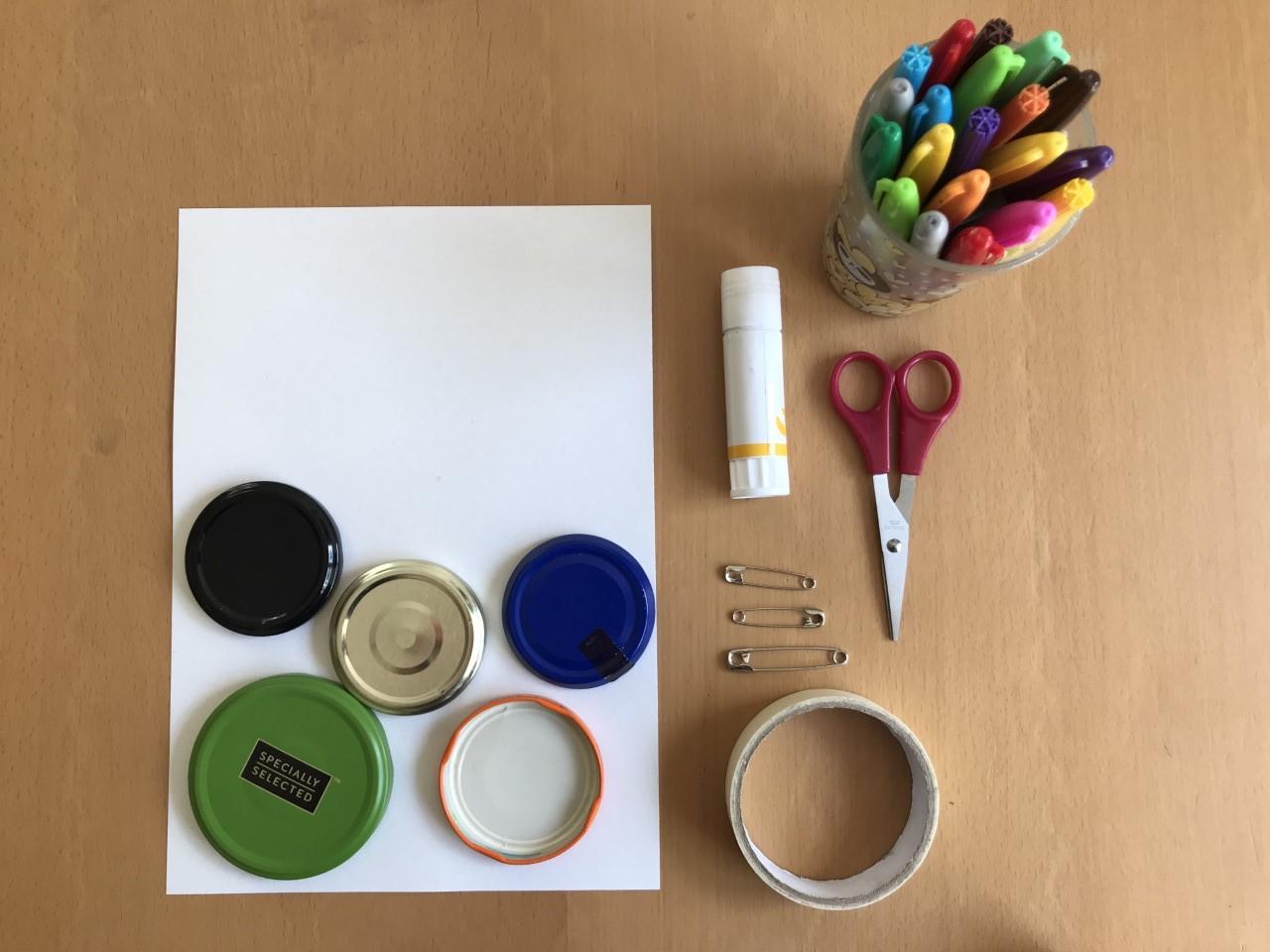 sheet of white paper, jam jar lids, glue, tape, scissors and coloured pens
