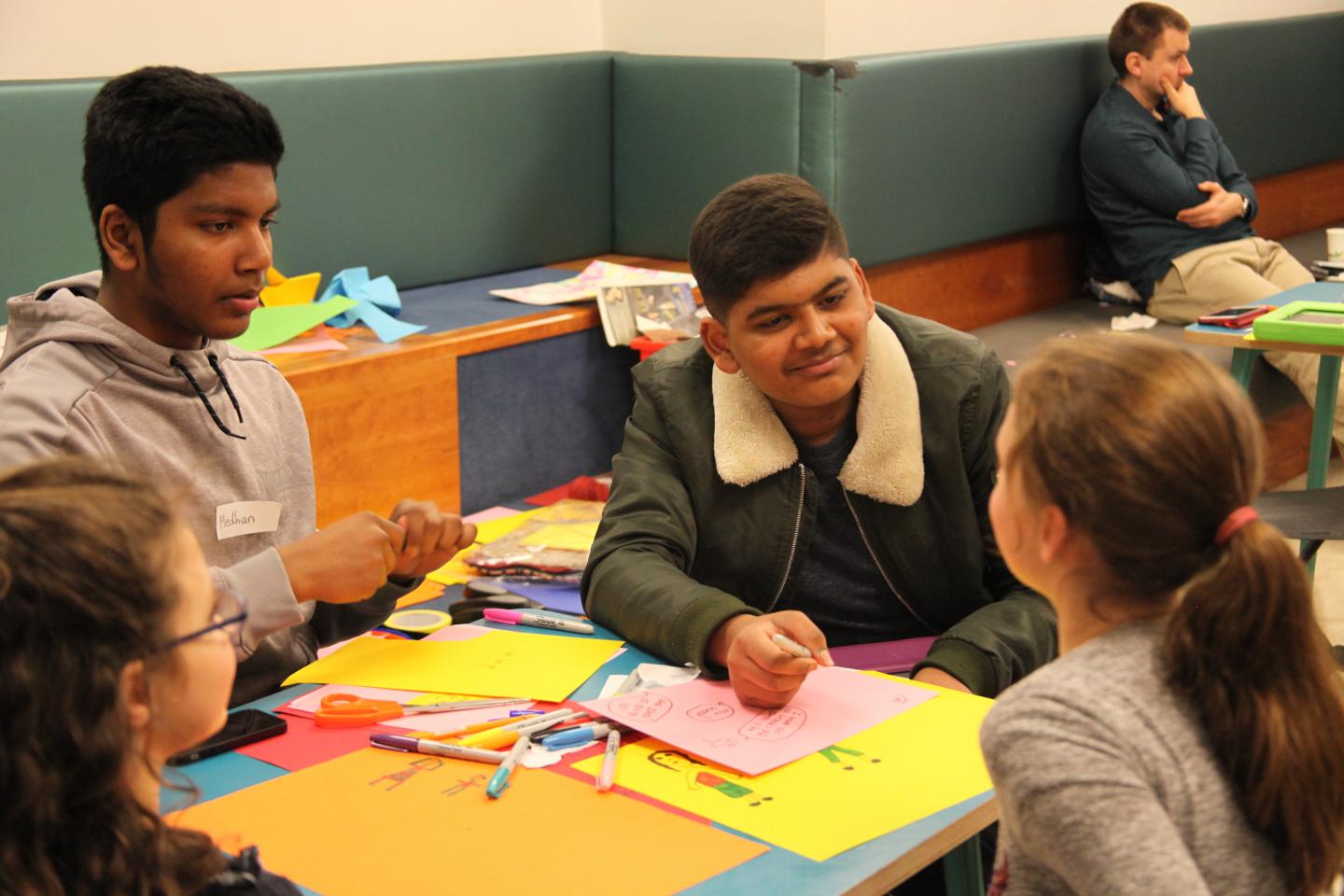 Two young people delivering a workshop to 2 children on animation and storyboarding