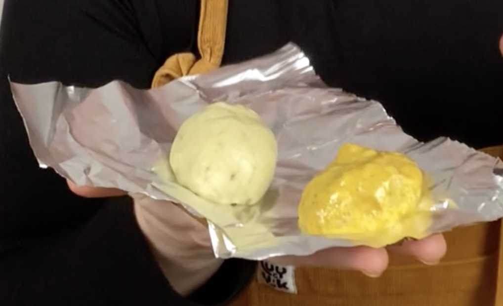 Two pieces of home made play dough. One is a light green colour and the other is yellow.