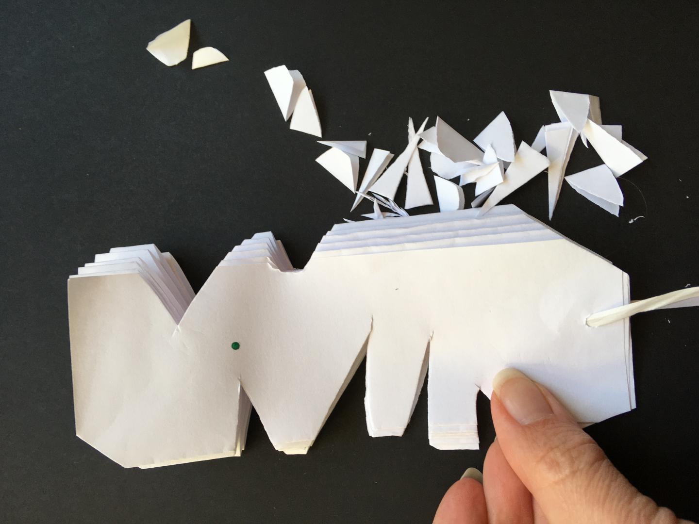 Cut shapes into pleated paper.