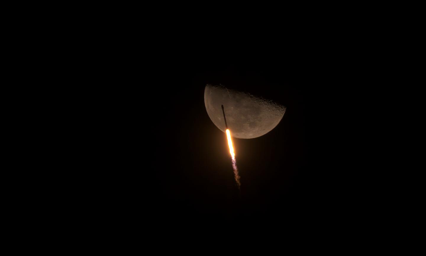 An astronomy photograph showing Falcon 9 soaring past the moon 