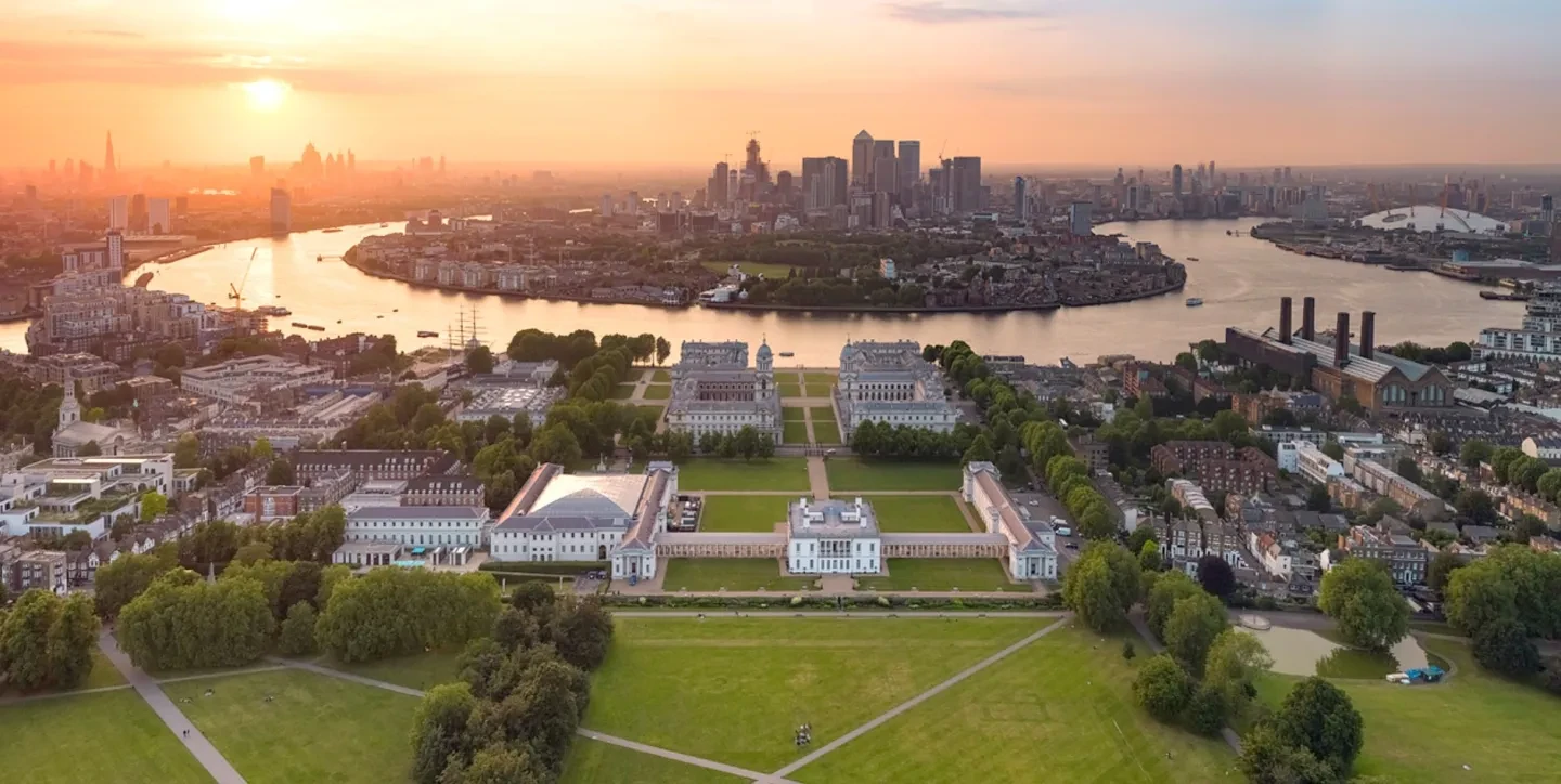 An aerial view of Greenwich, the Thames and Canary Wharf at sunset.