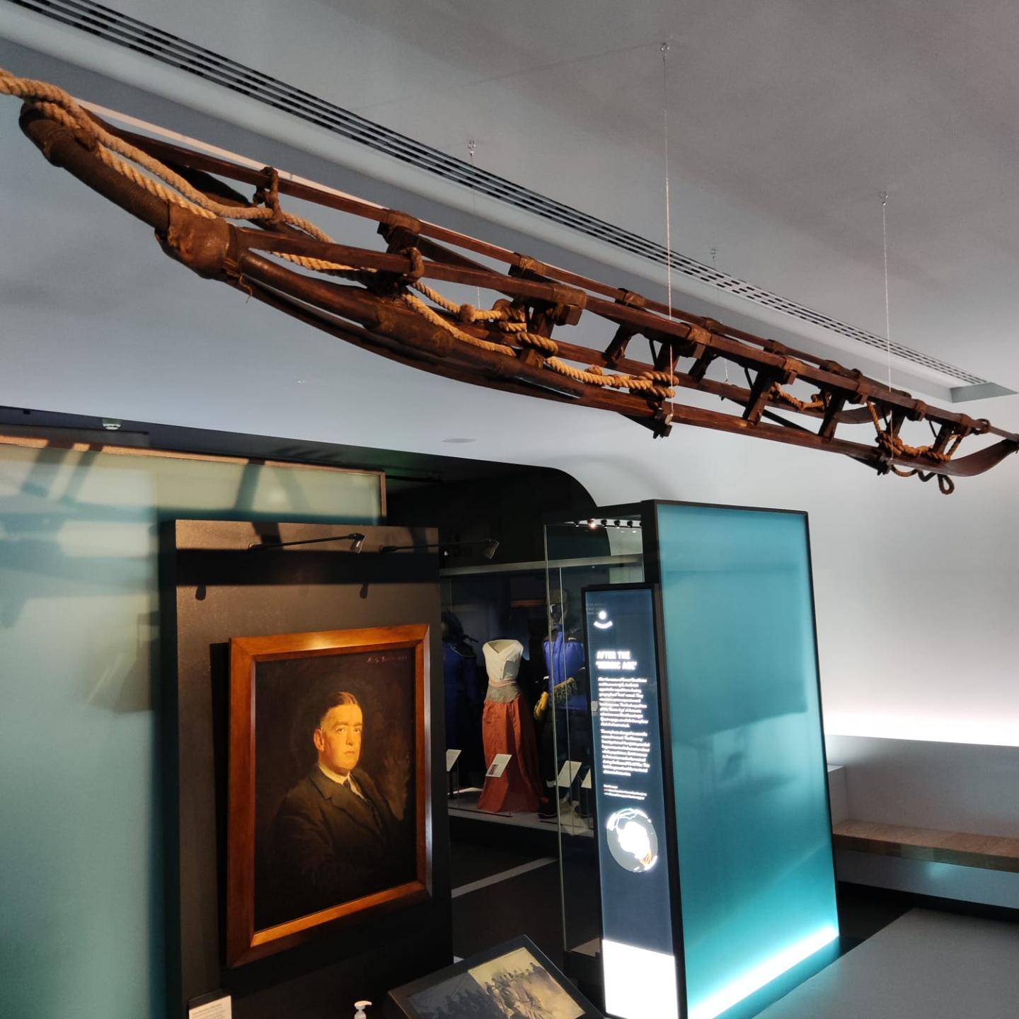 The sledge from Shackleton's Nimrod Expedition hanging in the Polar Worlds gallery at the National Maritime Museum above a portrait of Shackleton