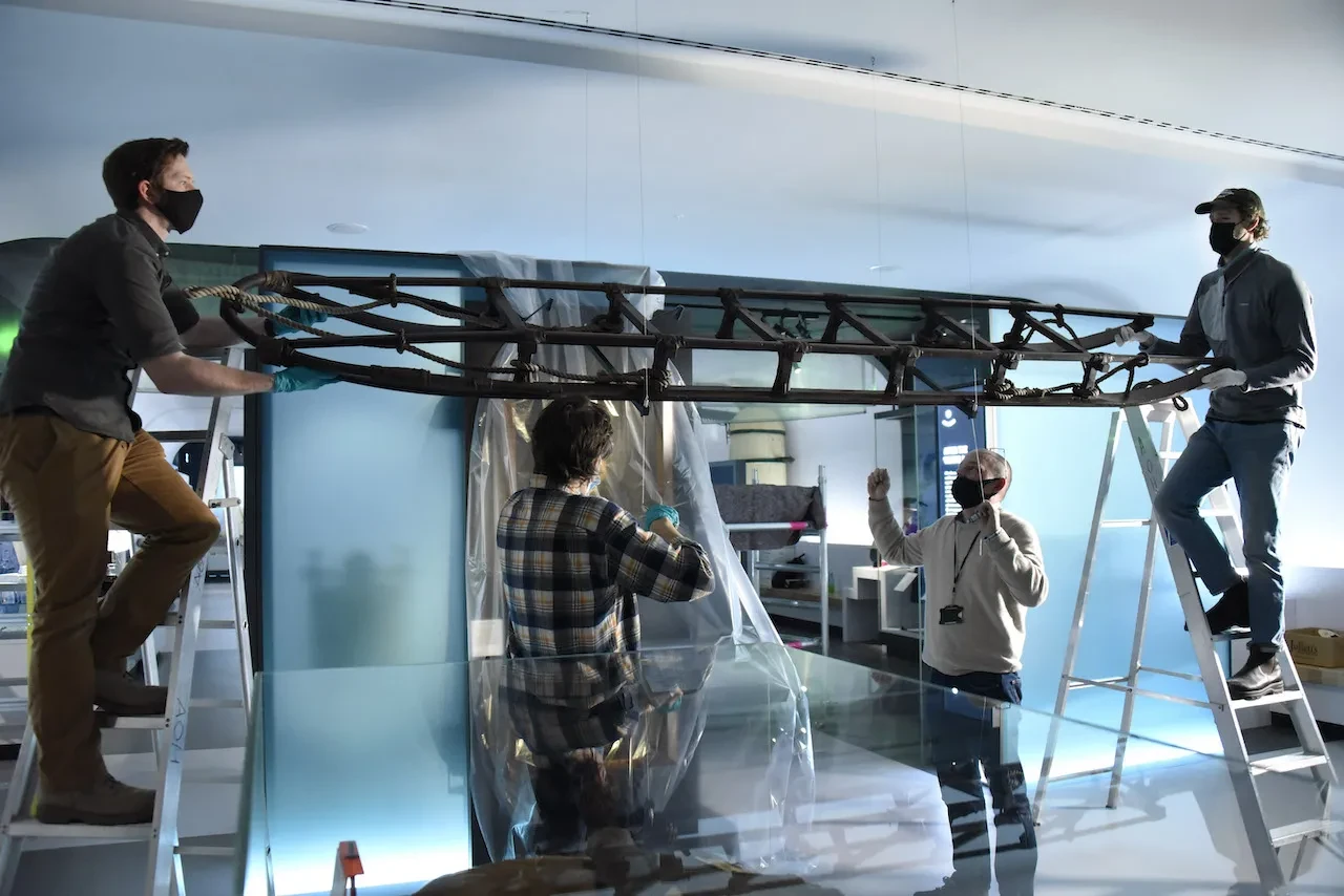 Object handlers lift the Shackleton sledge into position inside the National Maritime Museum gallery Polar Worlds