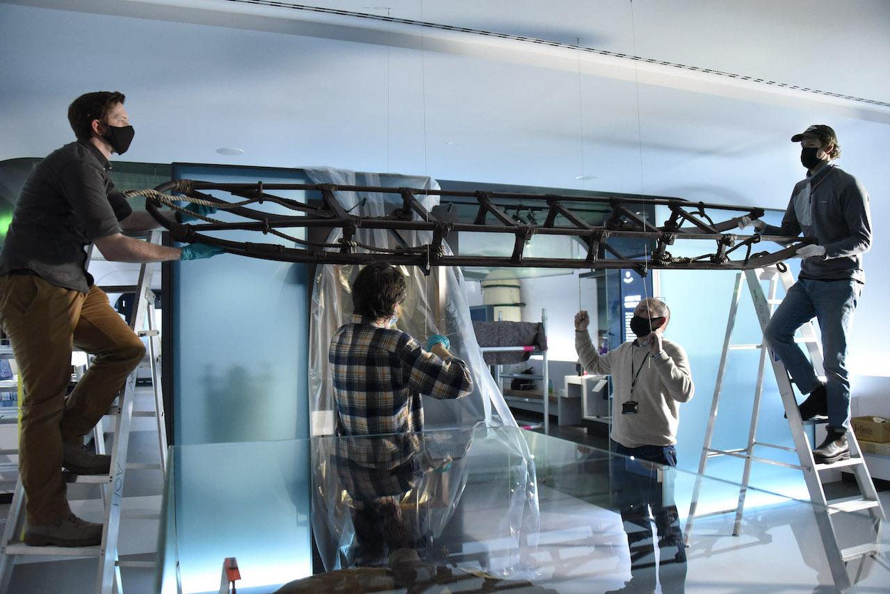 Object handlers lift the Shackleton sledge into position inside the National Maritime Museum gallery Polar Worlds