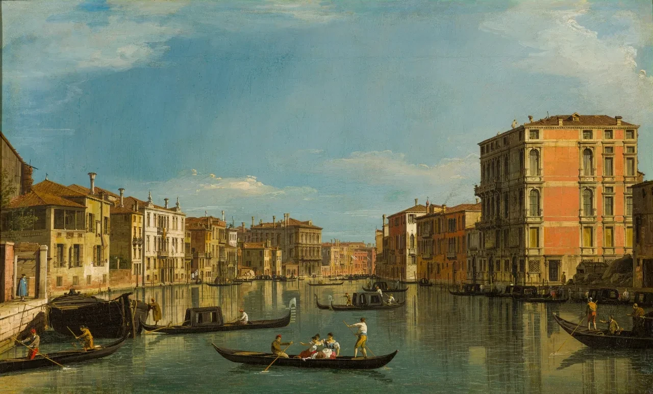 A painting of the Grand Canal in Venice by Canaletto. Gondolas dominate the foreground, with palaces and buildings lining the canal