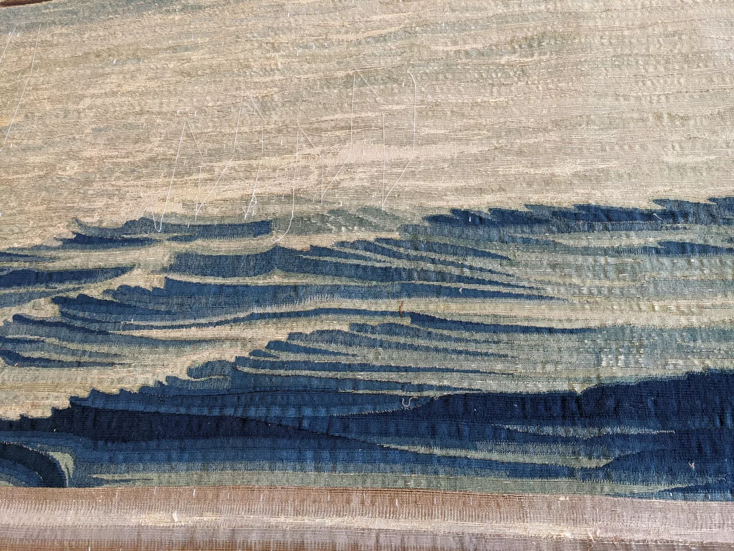 Detail of waves on a tapestry with stabilising white thread