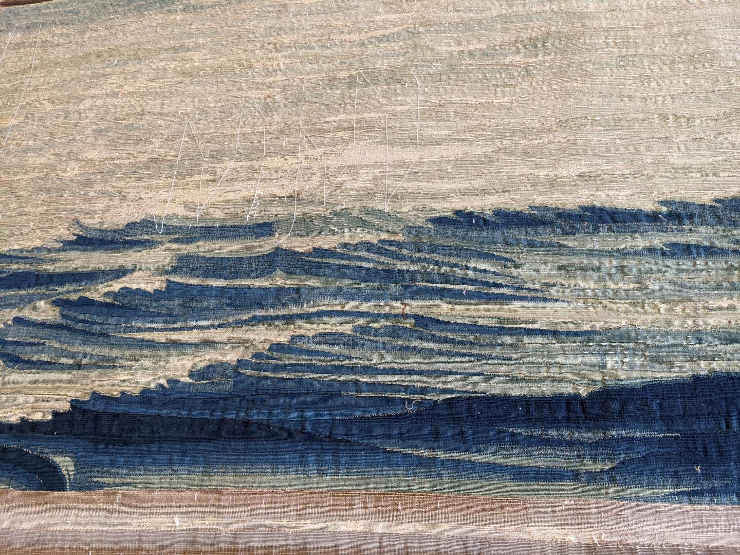 Detail of waves on a tapestry with stabilising white thread