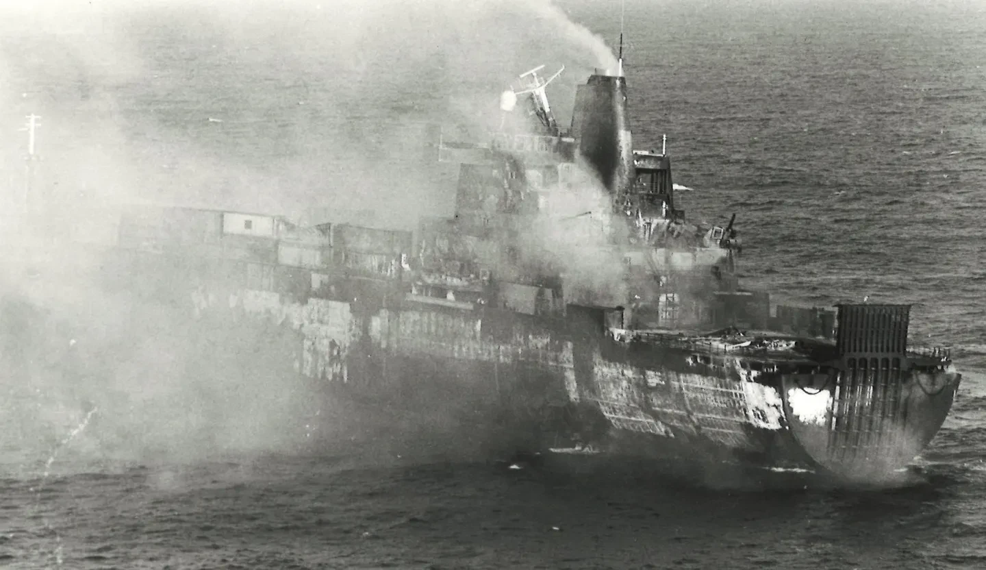Black and white photograph of a ship on fire in the Falklands