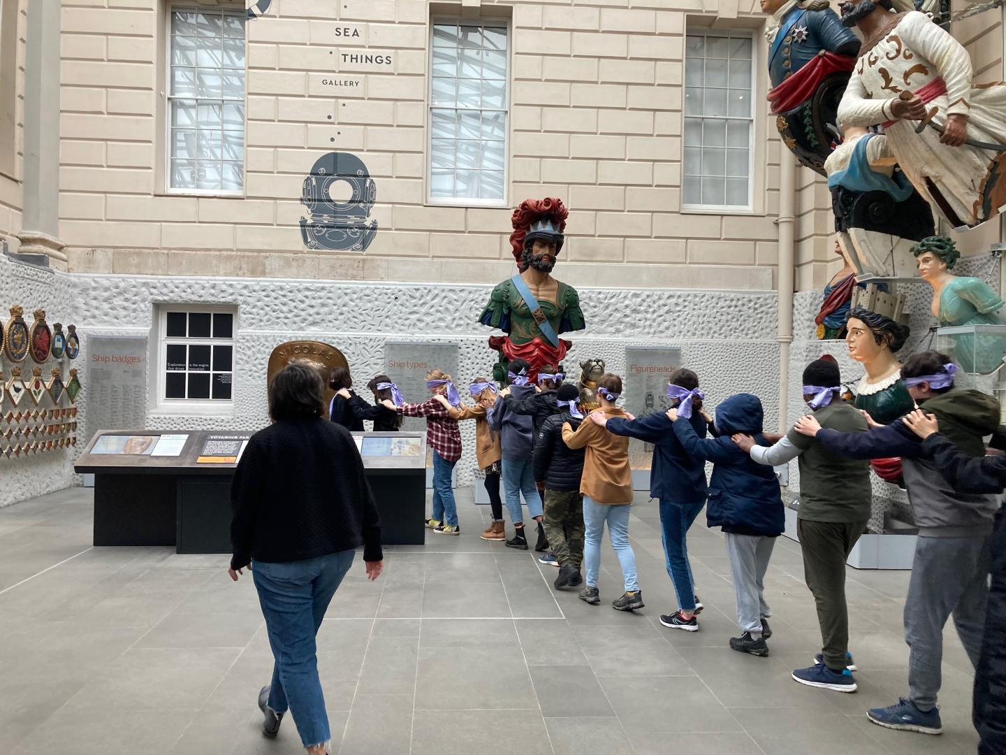 Young people walking through museum blindfold during sensory exploration of musuem
