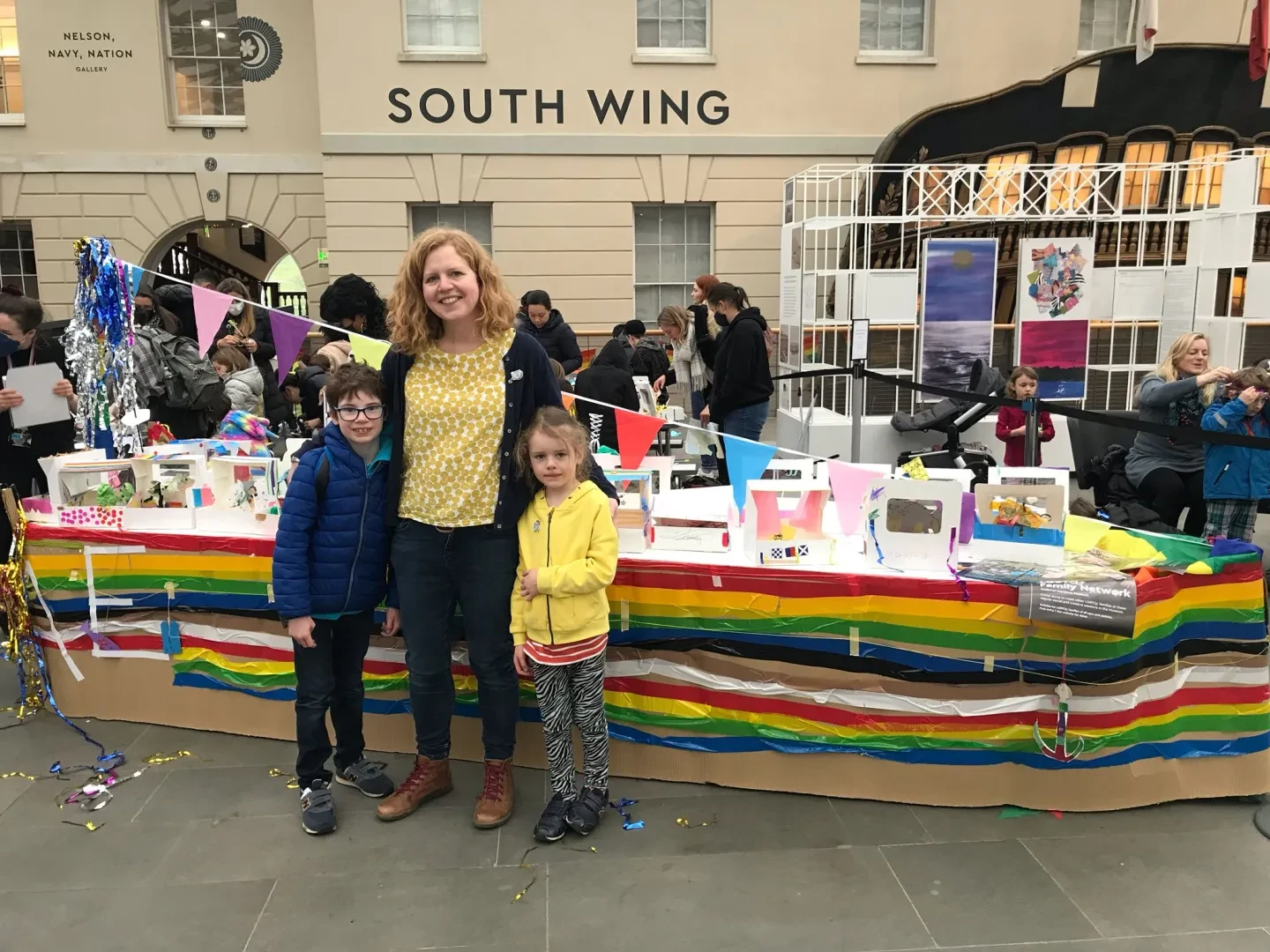 Family standing in front of a rainbow ship