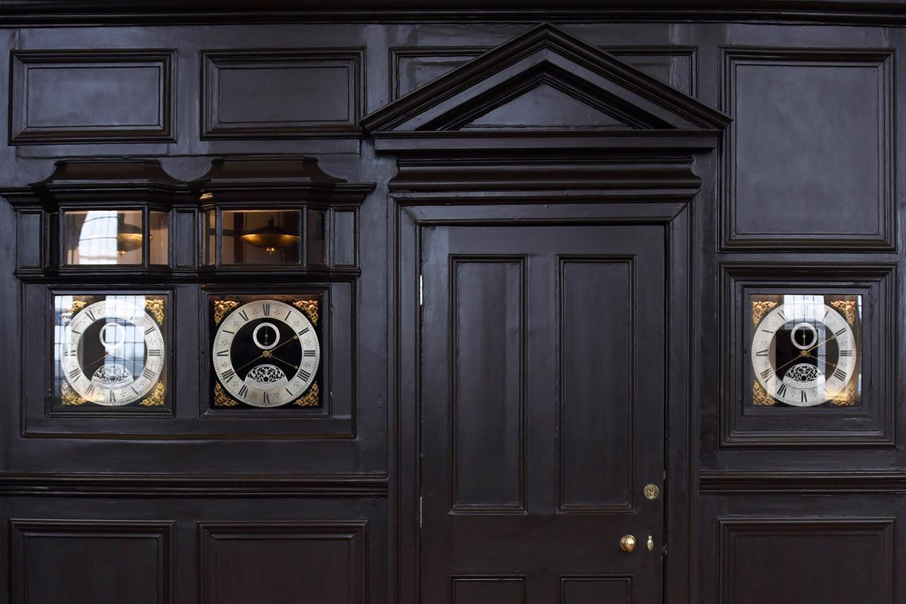 Clocks set into the dark wood panelling of the Octagon Room at the Royal Observatory 