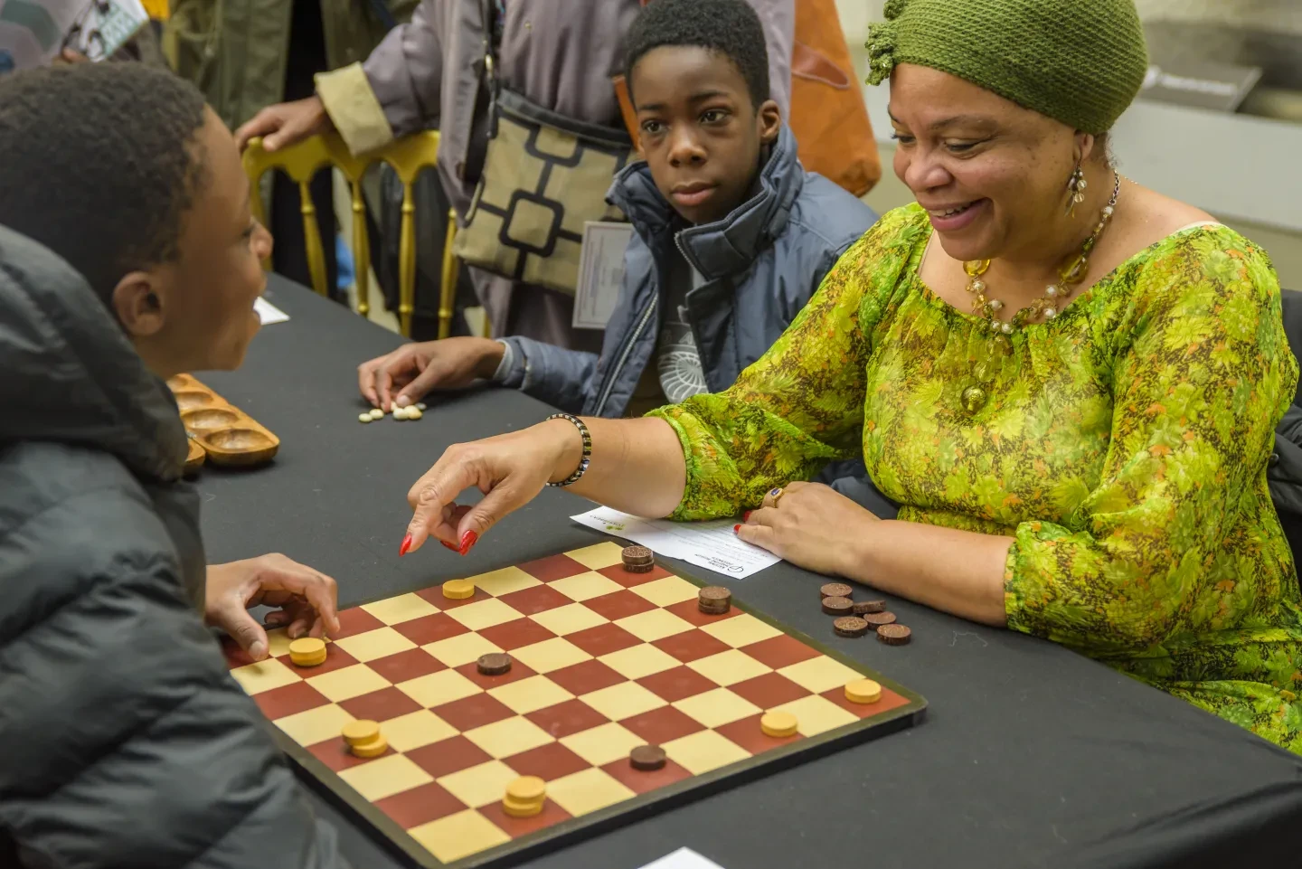 A group of people play dominoes