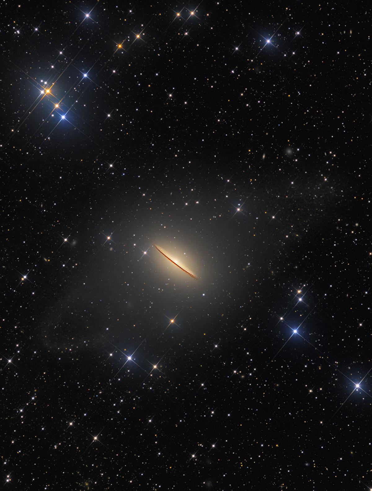 Image of a galaxy side-on, which is golden coloured and resembles a sombrero