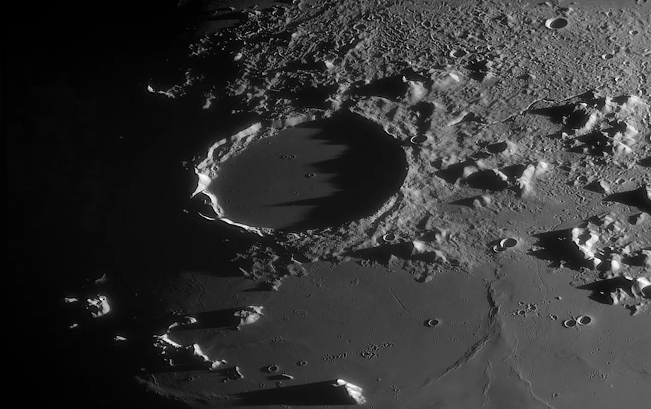 A close-up view of the Moon's surface, showing the feature known as 'Plato' in stark shadow