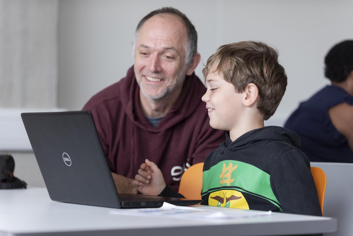 An adult and child enjoying being creative on a computer