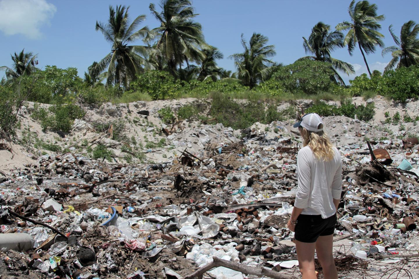 Emily Penn stands on a beach covered in litter