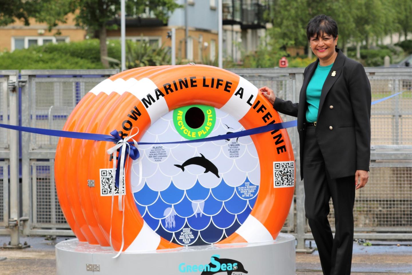 Fazilette Khan standing next to orange recycling bin