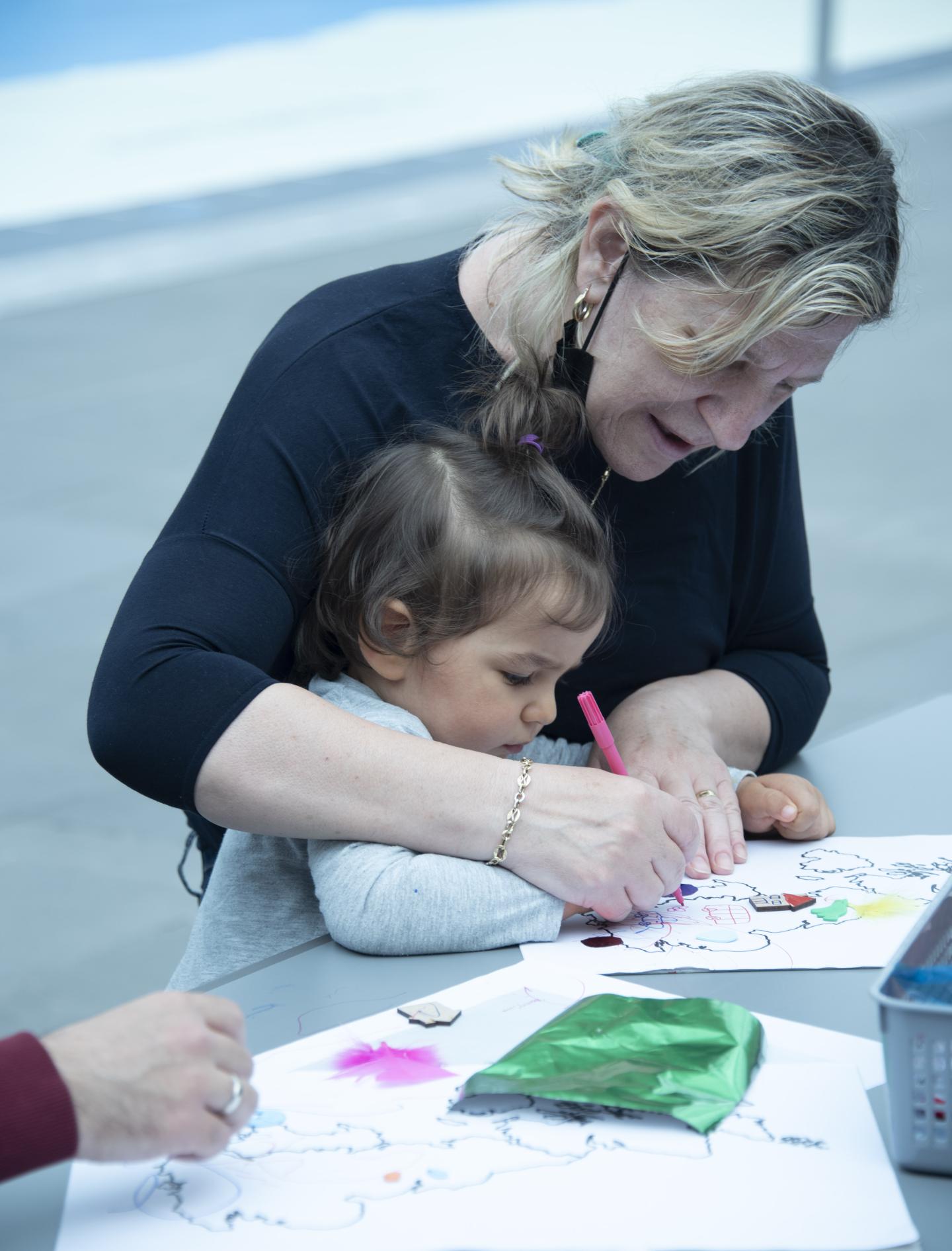 An adult and child draw together