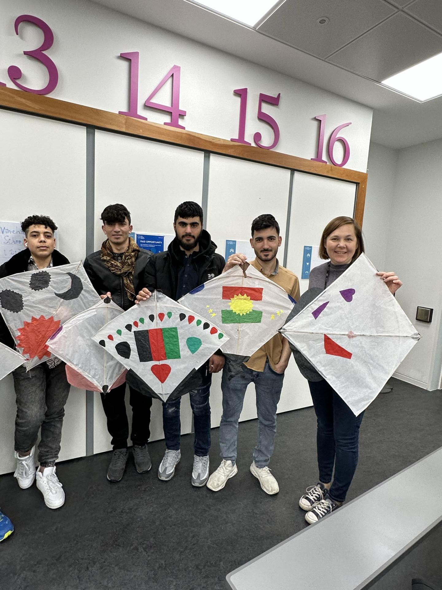 5 people holding kites