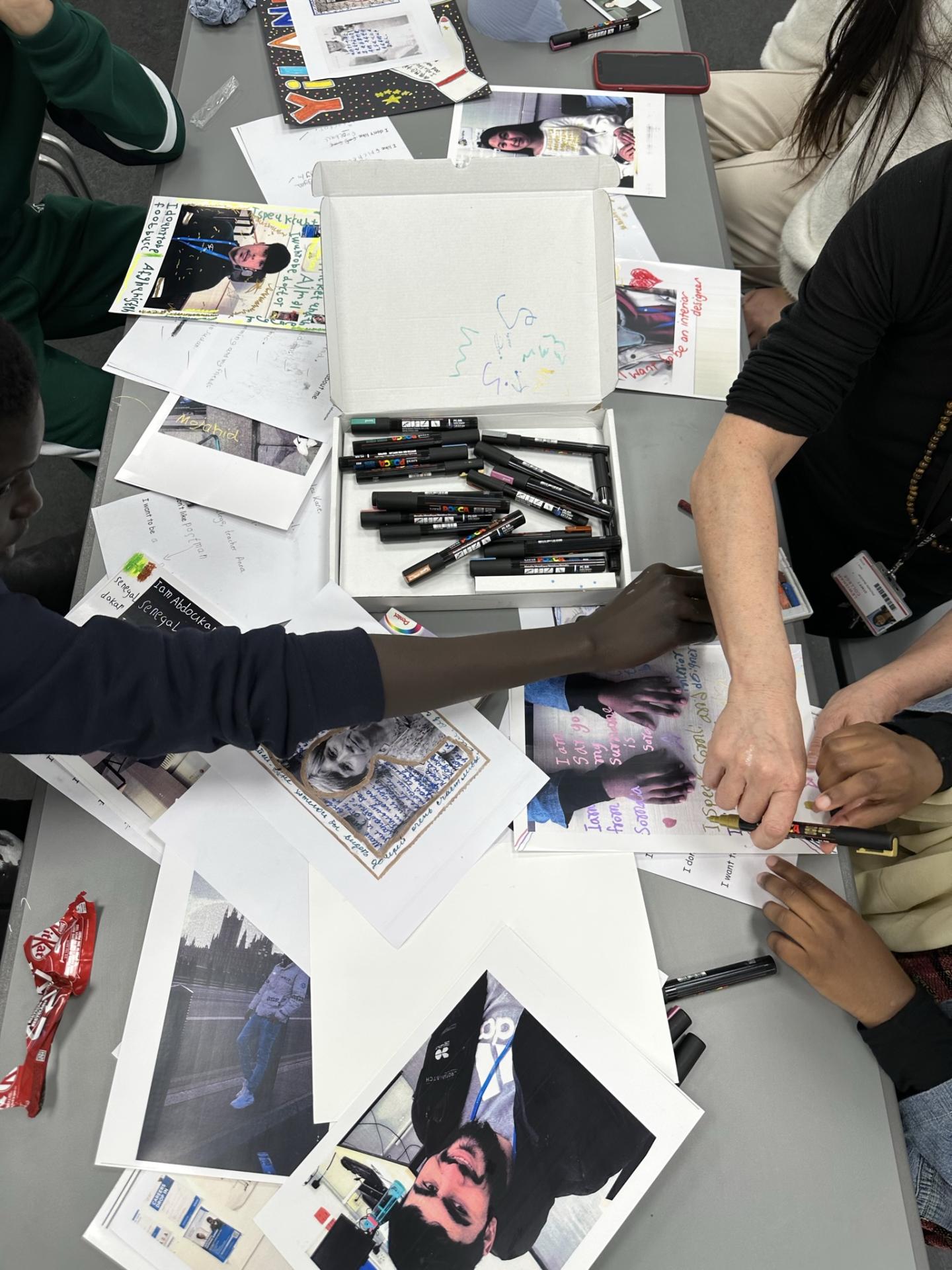 hands of students writing on their photos