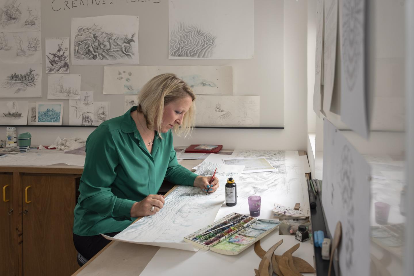 An artist draws in their studio