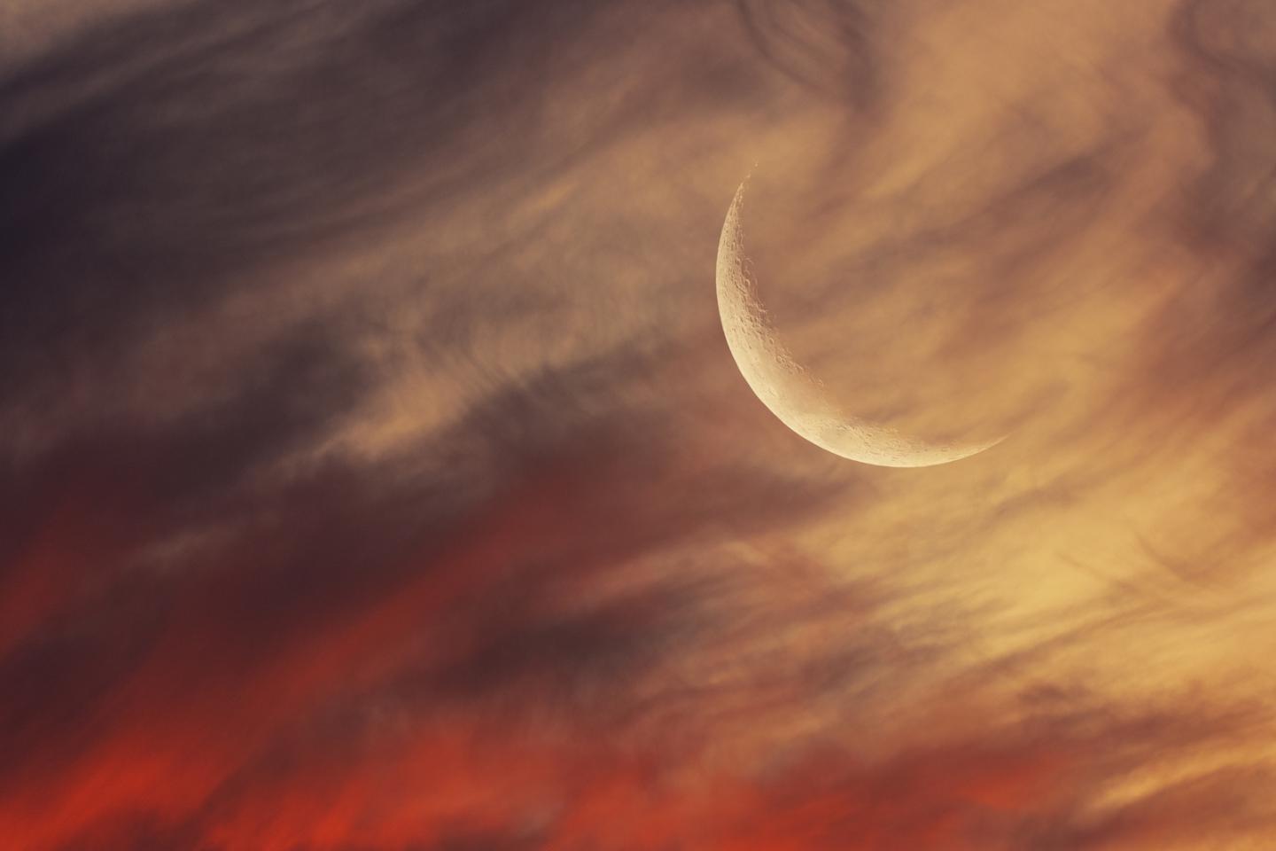 Crescent Moon in a red and cream cloudy sky
