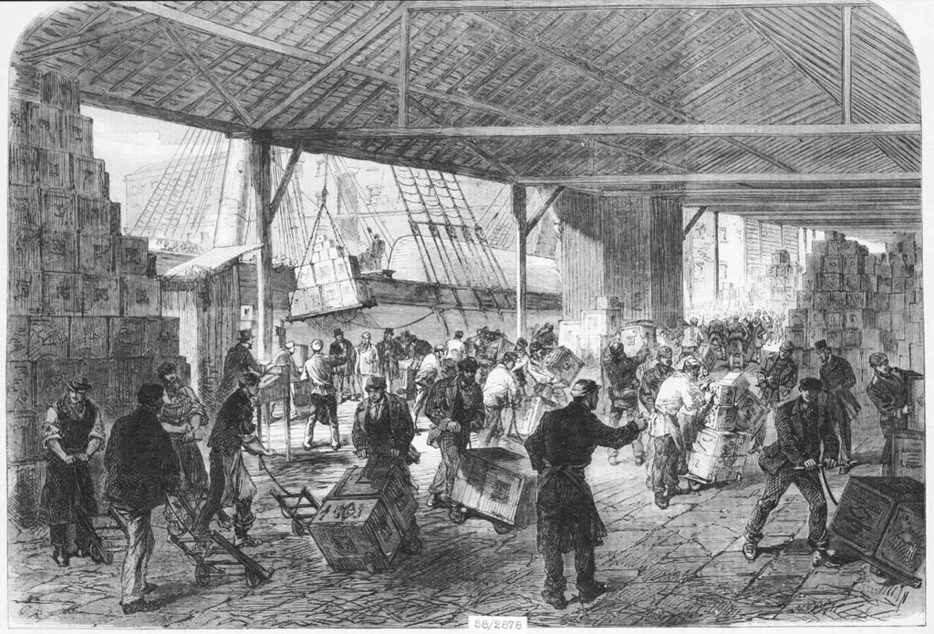Black and white drawing of East India Dock with a tea ship being unloaded by many workers and tea piled high in boxes.