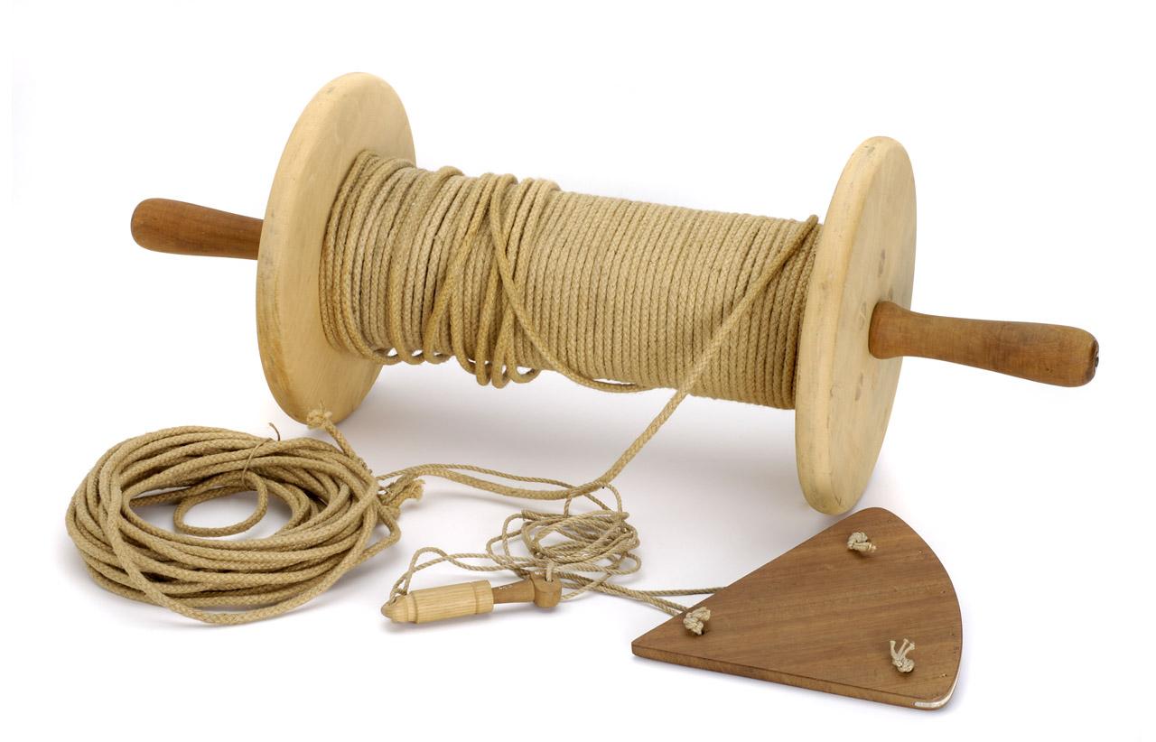 Image of a log and line, with string on a reel with a wooden triangle shape on the end