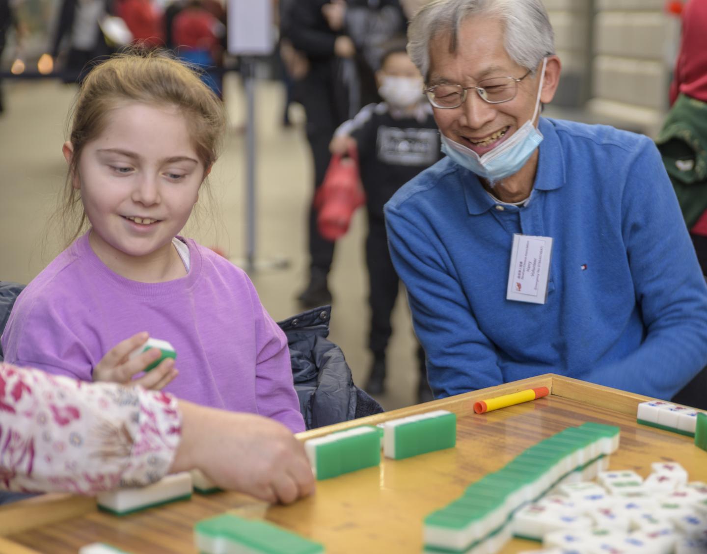 A child learns to play mahjong at the National Maritime Museum during Lunar New Year 