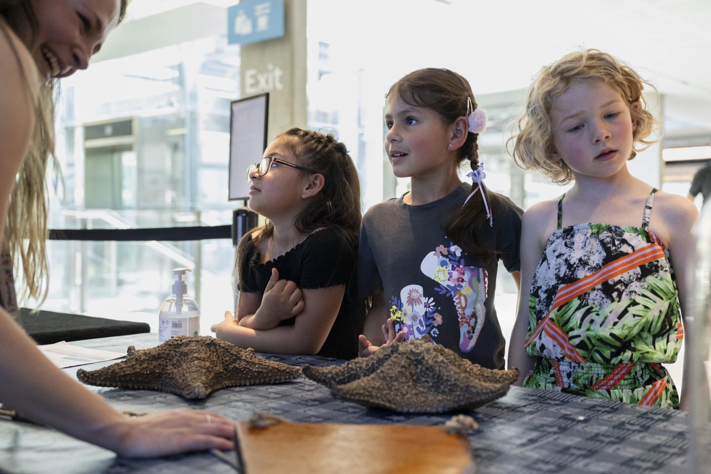 Three children take part in an object handling session at the National Maritime Museum