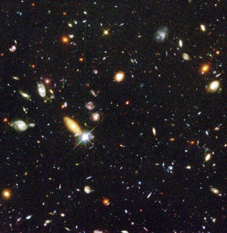 Image of patch of black night sky with hundreds of different galaxies in it which look different shapes, sizes and colours but all mainly circular