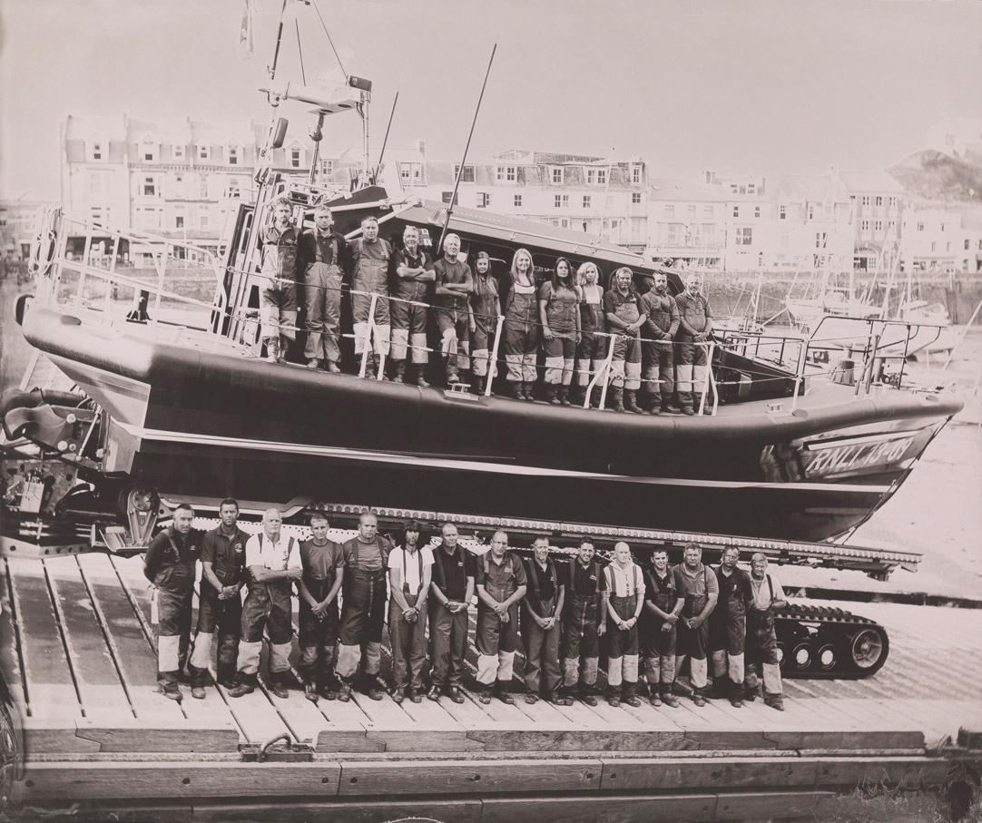 Black and white photograph of lifeboat crew standing beside a lifeboat at Ilfracombe