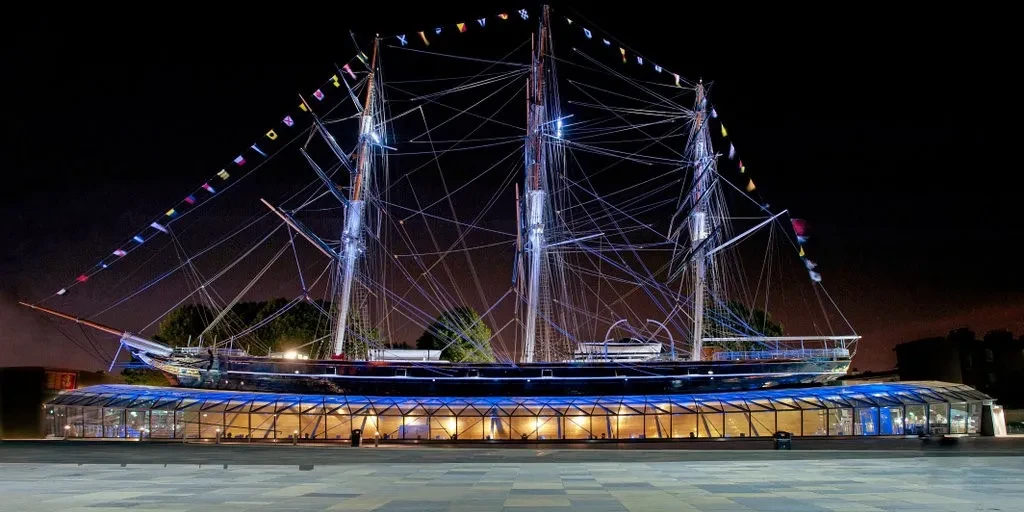 Side-on photo of the tea clipper Cutty Sark in Greenwich, on top of a glass Dry Dock.