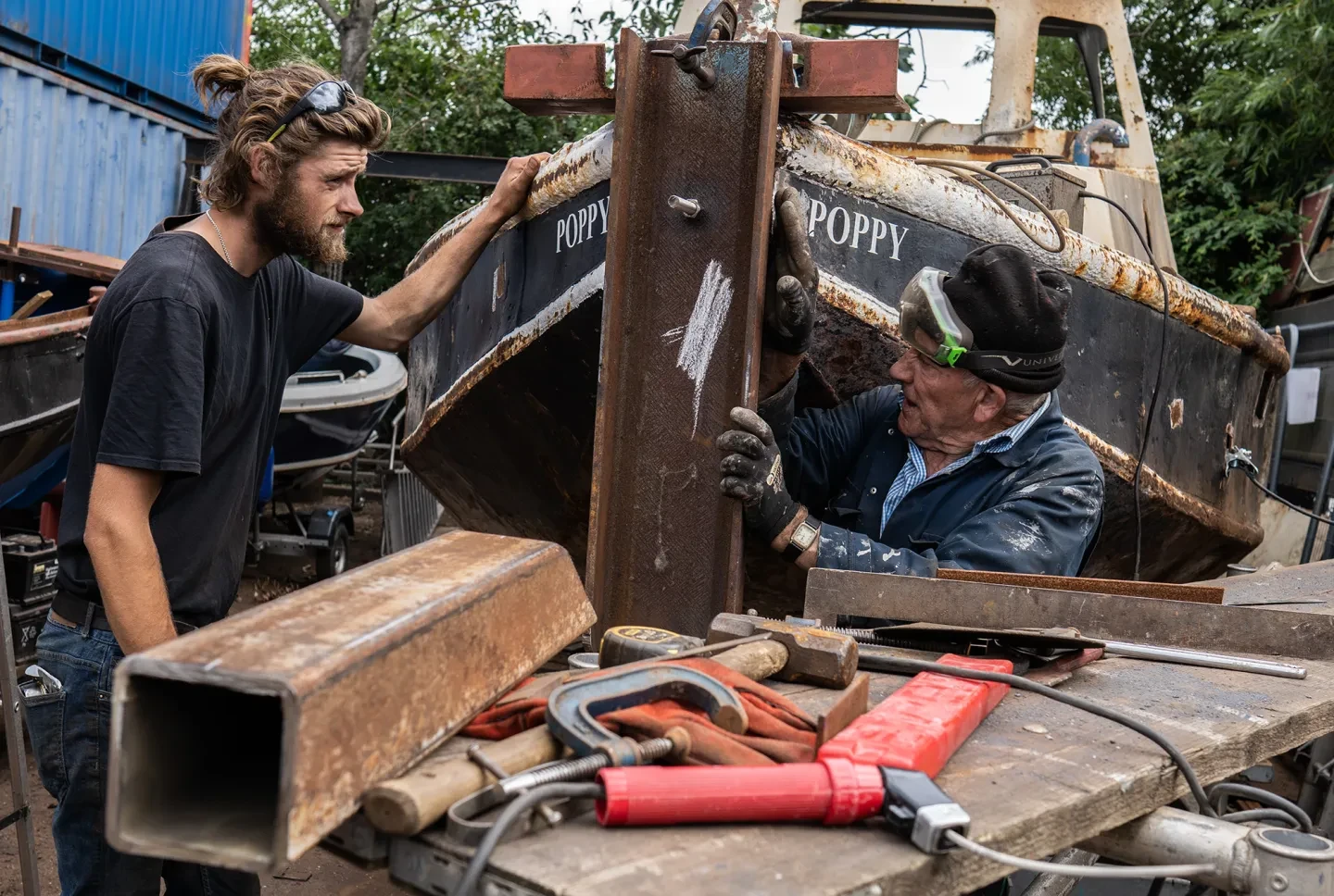 Two workers fix up a boat