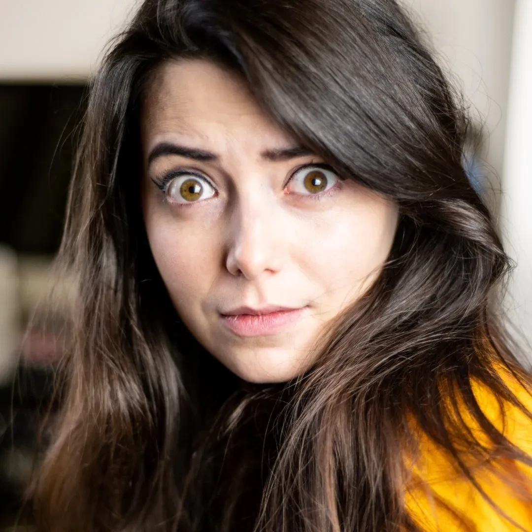 Josie looking side on towards the camera, brown eyes wide open, wearing yellow top