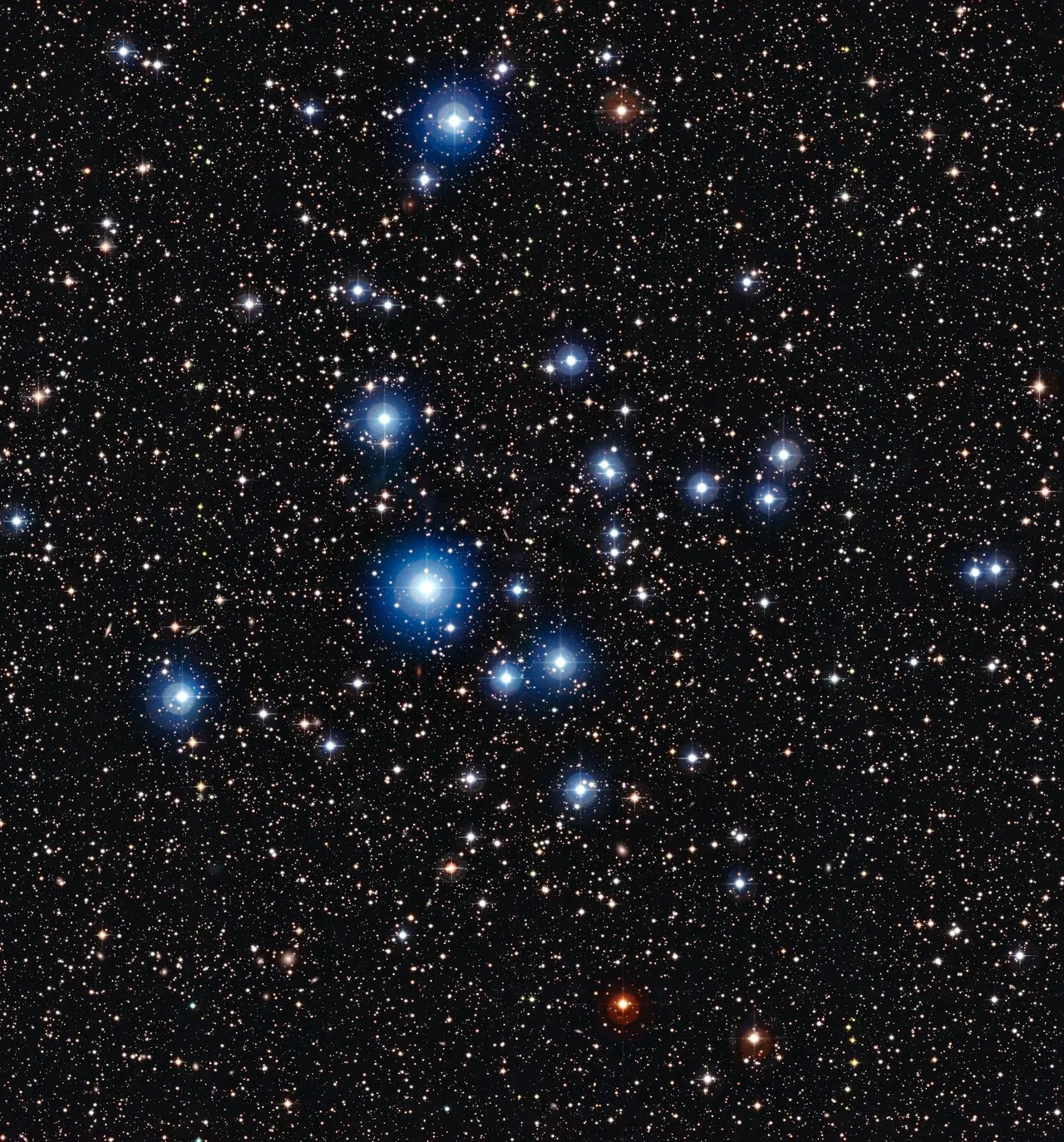 Photograph of star cluster, bright blue stars scattered on a background of fainter, distant stars