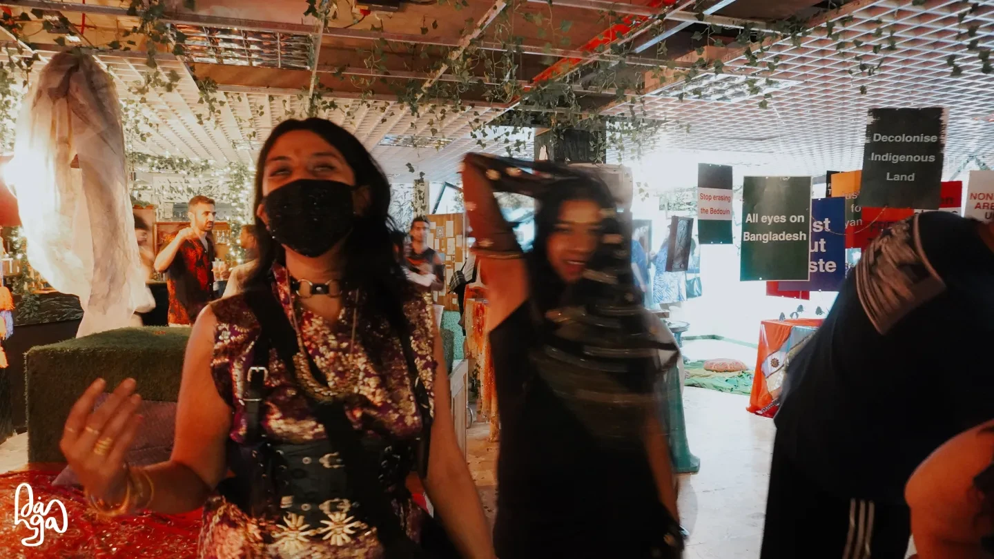 Photo of people in open space with signs hanging up in the background