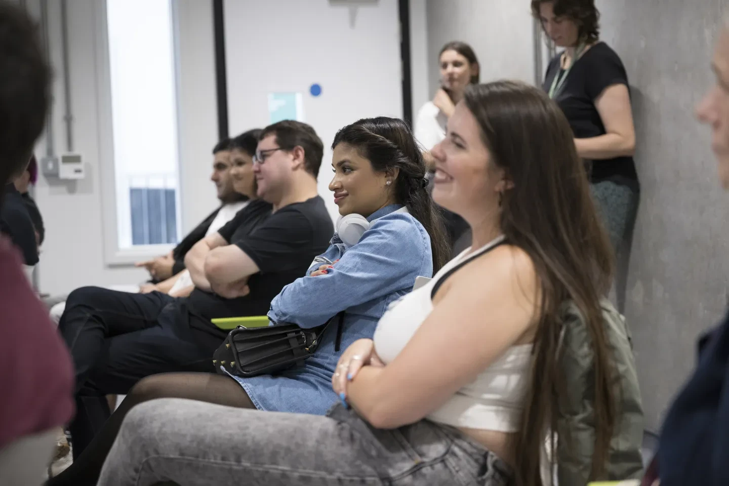 people sat in a row, listening to a speaker 