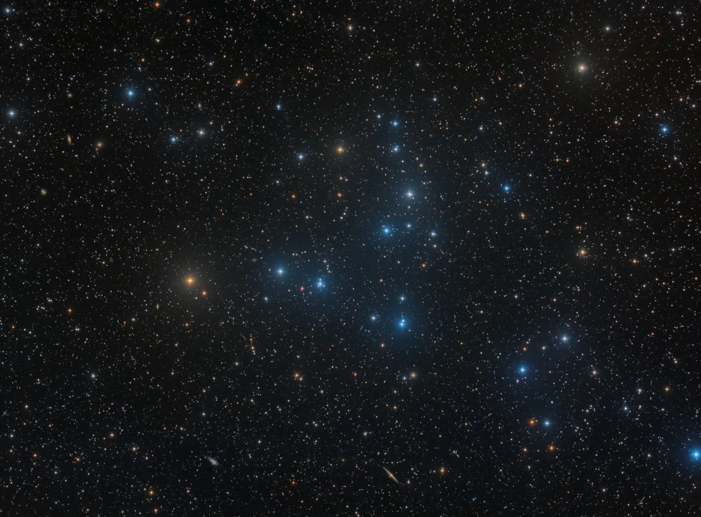 Photo of blue and yellow stars in a cluster in space.